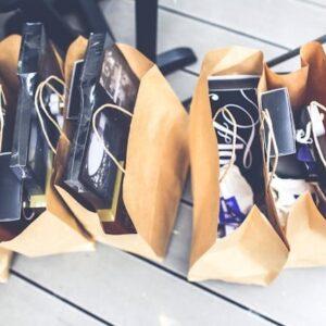 Cinco bolsas de cartón en el suelo llena de cosas.